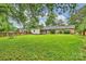 Beautiful backyard with lush green lawn, mature trees, brick fencing, and a charming detached garage at 1961 Runnymede Ln, Charlotte, NC 28211