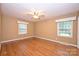 Spacious bedroom with hardwood floors and great natural light from two large windows at 1961 Runnymede Ln, Charlotte, NC 28211