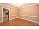 Bright dining room with wainscoting and hardwood floors, offering a glimpse into the kitchen area at 1961 Runnymede Ln, Charlotte, NC 28211