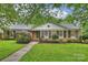 Charming brick home with manicured lawn, mature landscaping, black shutters, and a welcoming front walkway at 1961 Runnymede Ln, Charlotte, NC 28211