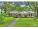 Attractive brick home with classic black shutters and a well-maintained front lawn with mature foliage at 1961 Runnymede Ln, Charlotte, NC 28211
