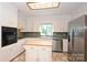 The kitchen features an island, stainless steel appliances, and white cabinets at 1961 Runnymede Ln, Charlotte, NC 28211