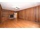 The living room features hardwood floors, wood paneling, and a brick fireplace at 1961 Runnymede Ln, Charlotte, NC 28211