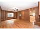 The living room features hardwood floors, wood paneling, and a window overlooking the yard at 1961 Runnymede Ln, Charlotte, NC 28211
