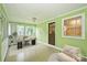 Bright, green-walled sunroom with tile floors, large windows and space for relaxing and working at 1961 Runnymede Ln, Charlotte, NC 28211
