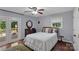 Cozy bedroom with a ceiling fan, white bedding, wood floors, and access to the deck at 2010 Dogwood Trl, Shelby, NC 28150