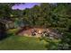 Backyard with a custom brick fire pit and seating area overlooking serene water at 2010 Dogwood Trl, Shelby, NC 28150