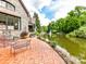 Scenic backyard with brick patio overlooking the water feature at 2240 La Maison Dr, Charlotte, NC 28226