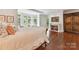 Inviting bedroom with a fireplace, hardwood floors, and natural light streaming through large windows at 2240 La Maison Dr, Charlotte, NC 28226