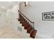 Staircase with hardwood steps, decorative wrought iron railings, and tiled floors at 2240 La Maison Dr, Charlotte, NC 28226