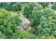 A captivating aerial view showcases a home nestled in a lush, mature forest, offering a serene and private setting at 2314 Winding Oaks Trl, Waxhaw, NC 28173