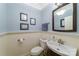 Cozy powder room with beadboard paneling, framed art, and a pedestal sink at 2314 Winding Oaks Trl, Waxhaw, NC 28173