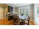Cozy dining area with large windows, hardwood floors, and dark wood table with seating for six at 2314 Winding Oaks Trl, Waxhaw, NC 28173