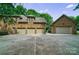 Exterior view of a brick home featuring a three-car garage and a separate single-car garage at 2314 Winding Oaks Trl, Waxhaw, NC 28173