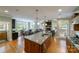 Open-concept kitchen with island sink, stainless steel appliances, and view to living space and breakfast nook at 2314 Winding Oaks Trl, Waxhaw, NC 28173