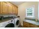 Functional laundry room with built-in cabinets, countertops, sink, and modern washer and dryer at 2314 Winding Oaks Trl, Waxhaw, NC 28173