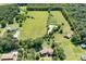 Expansive aerial view of a large estate with a pond, lush greenery, and multiple structures surrounded by trees at 24008 Carriker Rd, Albemarle, NC 28001