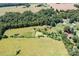 An aerial view shows a sprawling property with a home, pond, and ample green space at 24008 Carriker Rd, Albemarle, NC 28001