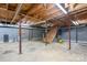 Unfinished basement with exposed wood ceiling, concrete flooring, and wood stairs at 24008 Carriker Rd, Albemarle, NC 28001