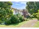 Lush landscaping surrounds this Tudor-style home, adding to its charm and curb appeal at 24008 Carriker Rd, Albemarle, NC 28001