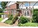 Charming brick home featuring a pergola-covered deck with lush greenery and garden leading to walk out basement at 24008 Carriker Rd, Albemarle, NC 28001