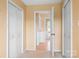 Hallway with beige walls and multiple closets and doorways at 24008 Carriker Rd, Albemarle, NC 28001