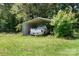 A covered parking spot with an older pickup truck sits amidst a grassy and wooded area at 24008 Carriker Rd, Albemarle, NC 28001