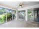 Enclosed sun room with ceiling fan and walls of windows bringing in natural light at 24008 Carriker Rd, Albemarle, NC 28001
