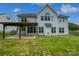 Spacious backyard featuring a covered patio, lush lawn, and the home's exterior with multiple windows at 2479 N Legacy Park Blvd, Fort Mill, SC 29707