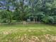 Fenced backyard with mature trees and a small shed, offering a private and serene outdoor space at 2479 N Legacy Park Blvd, Fort Mill, SC 29707