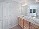 Bright bathroom featuring double vanity with light wood cabinets, large mirror, and separate tub and shower at 2479 N Legacy Park Blvd, Fort Mill, SC 29707