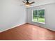 A bright bedroom with wood floors, ceiling fan, and a large window overlooking a fenced yard at 2479 N Legacy Park Blvd, Fort Mill, SC 29707