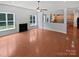 Open concept living room with fireplace and adjacent kitchen with wood floors and neutral paint at 2479 N Legacy Park Blvd, Fort Mill, SC 29707