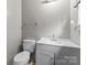 This bathroom features a toilet, sink, and vanity combination with white features and neutral decor at 301 Honeywood Ave, Charlotte, NC 28216