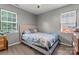 Cozy bedroom with wood-look floors, two windows and a plush upholstered headboard at 301 Honeywood Ave, Charlotte, NC 28216