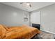 Neutral bedroom features ceiling fan, and an orange comforter set against gray walls and wood-look laminate floors at 301 Honeywood Ave, Charlotte, NC 28216