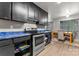 View of the black kitchen with blue countertops that connects to the dining room and living room at 301 Honeywood Ave, Charlotte, NC 28216