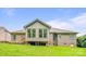 Brick home's back exterior featuring a sunroom, patio, lush lawn, and mature landscaping for privacy at 305 River Birch Cir, Mooresville, NC 28115