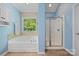 Well-lit bathroom featuring a shower, a soaking tub, and a window looking out to greenery at 305 River Birch Cir, Mooresville, NC 28115