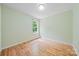 Neutral-toned bedroom with hardwood floors and a large window offering natural light at 305 River Birch Cir, Mooresville, NC 28115