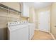 Laundry room featuring modern washer and dryer, storage shelves, and utility sink at 305 River Birch Cir, Mooresville, NC 28115