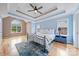 Light-filled main bedroom featuring tray ceiling, hardwood floors, and ample windows at 305 River Birch Cir, Mooresville, NC 28115