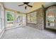Inviting sunroom with plenty of windows, ceiling fan, and brick accent wall at 305 River Birch Cir, Mooresville, NC 28115