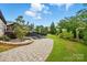 Lush backyard features a stone patio, manicured lawn, and mature landscaping at 5357 Pembrey Dr, Denver, NC 28037