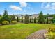 Manicured backyard with lush lawn, mature trees, and a classic wrought iron fence at 5357 Pembrey Dr, Denver, NC 28037