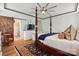 A bedroom with a dark wooden four-poster bed, light colored walls, and access to the bathroom through a sliding door at 5357 Pembrey Dr, Denver, NC 28037