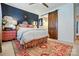 A bedroom featuring dark blue accent walls, wooden floors, and unique wooden sliding doors at 5357 Pembrey Dr, Denver, NC 28037