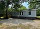 Charming one-story home with light green siding, stone facade, a wooden porch, and gravel landscaping at 5458 Foxcroft Dr, Fort Lawn, SC 29714