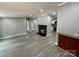 Bright living room showcasing a stone fireplace, gray walls, and open layout to the kitchen at 5458 Foxcroft Dr, Fort Lawn, SC 29714