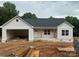 Charming single-story home with a light gray exterior, front porch, and an attached two-car garage at 63 Cornerstone Dr, Taylorsville, NC 28681